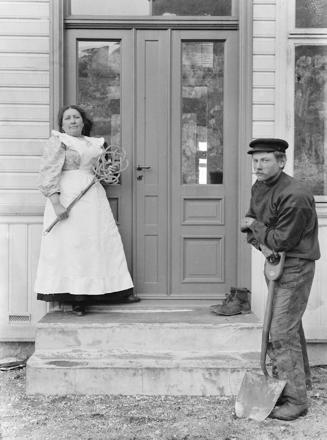 A woman and man stand on a porch.